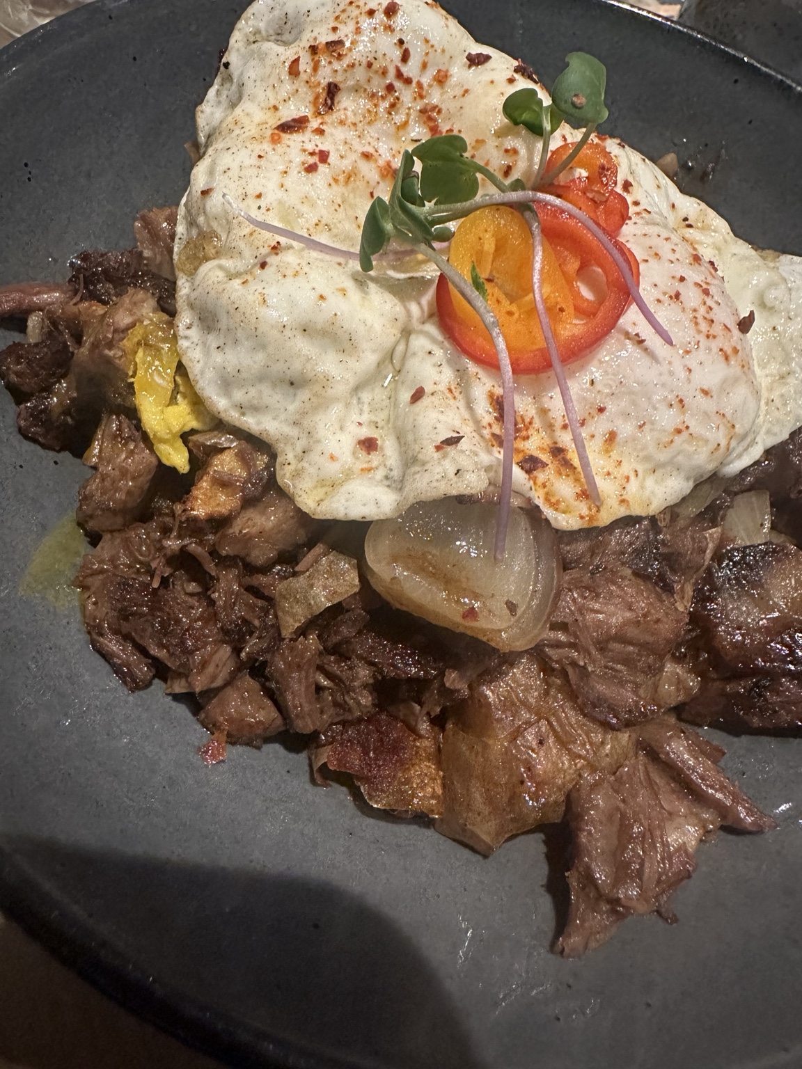 Chopped beef topped with eggs and fresh garnish