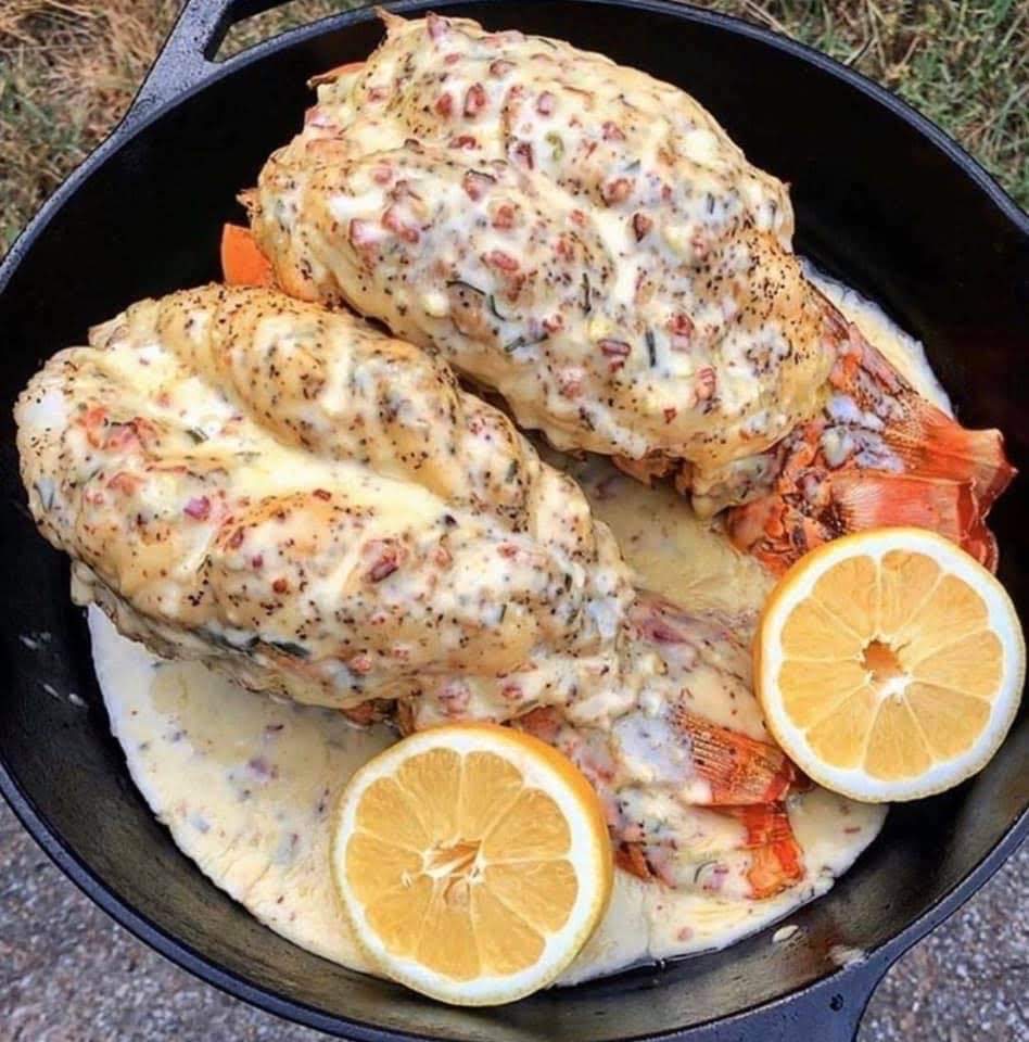 Lobster tails with creamy sauce and lemon in a skillet