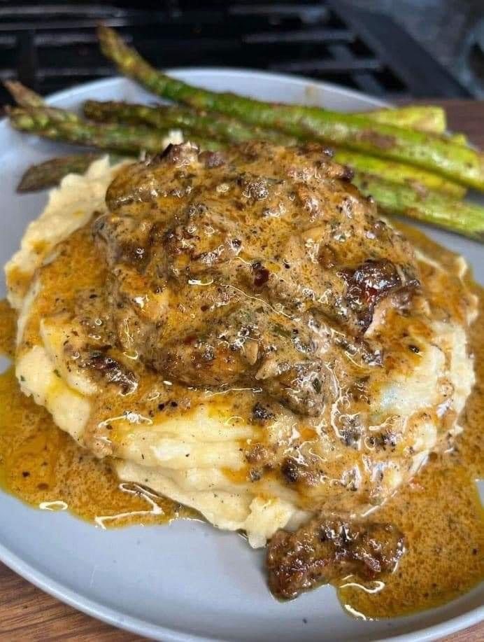Plated entree with mashed potatoes, sauce and asparagus