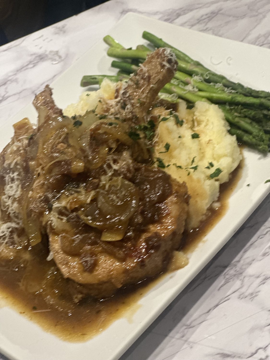 Savory plated entree with mashed potatoes and green vegetables