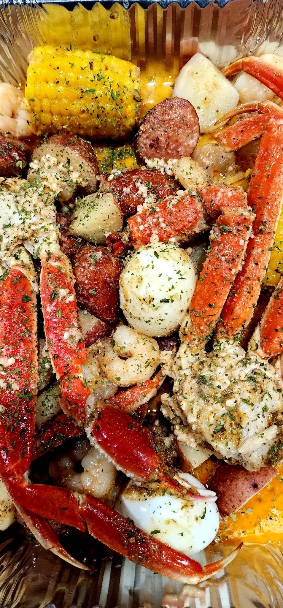 Seafood boil with crab, shrimp, sausage, potatoes, corn and eggs